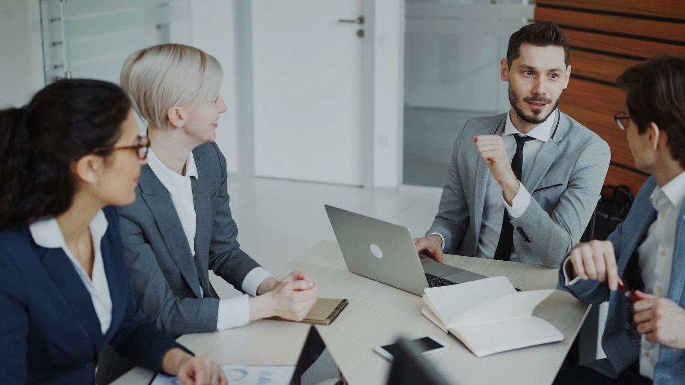 How We Support Group session around a table with documents