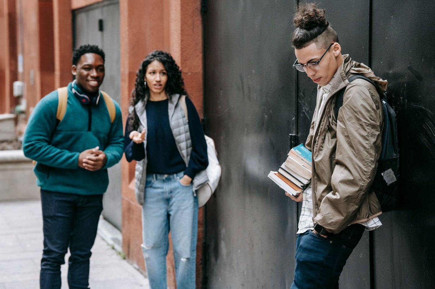 Students with backpacks talking outside a college building